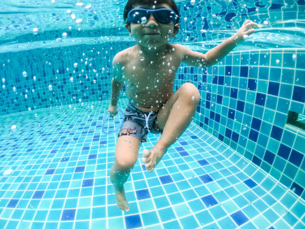 istock Asian little boy swimming and pick up objects underwater 1273898677