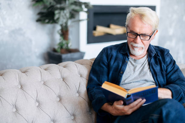 istock Mature man in eyeglasses is reading a book 1273899516