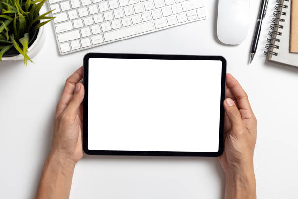 istock Top View Hand man holding tablet with mockup blank screen on white office desk 1273901904