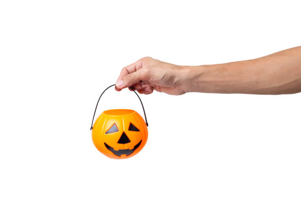 istock hand holding Halloween bucket isolated on white background. 1273901962