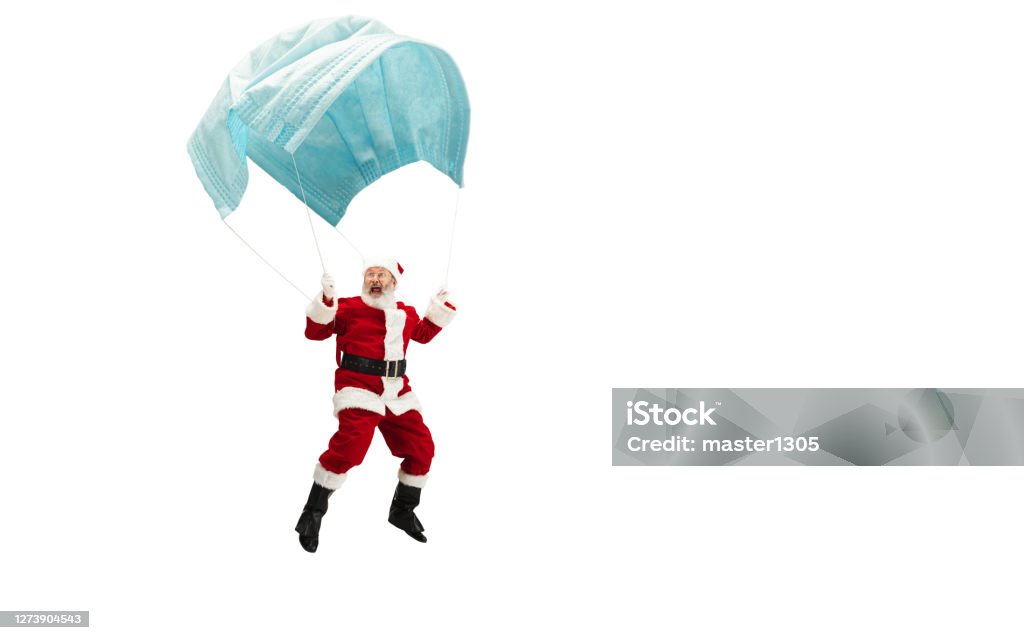 De Kerstman die op reusachtig gezichtsmasker als op ballon vliegt die op witte achtergrond wordt geïsoleerd - Royalty-free Humor Stockfoto