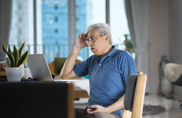 istock Worried senior man using laptop at home 1273906508