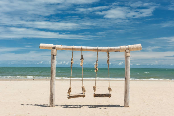 istock Wooden rope swing on beach in summer 1273907658