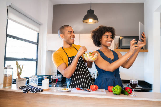 istock Latin couple cooking together and taking a selfie. 1273909739