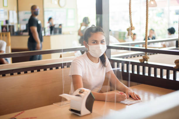 istock Woman is eating in Restaurant with social distancing protocol while lockdown City due to  Coronavirus pandemic 1273911647