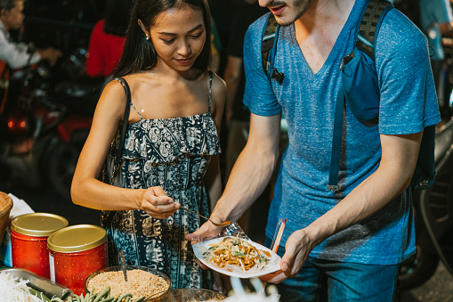 Young couple looking for street food in Bangkok