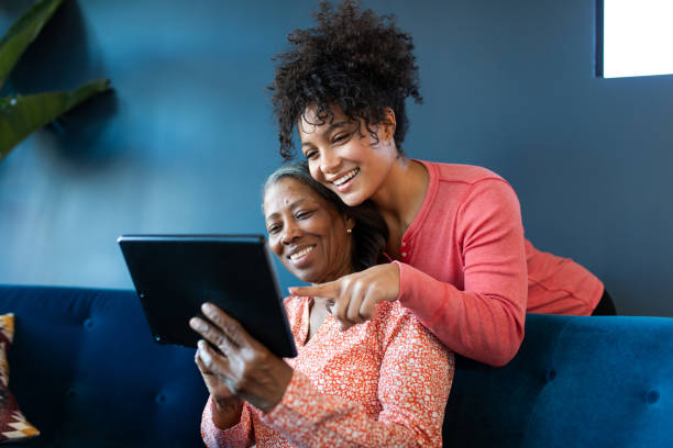 making a video call - wireless technology cheerful granddaughter grandmother imagens e fotografias de stock