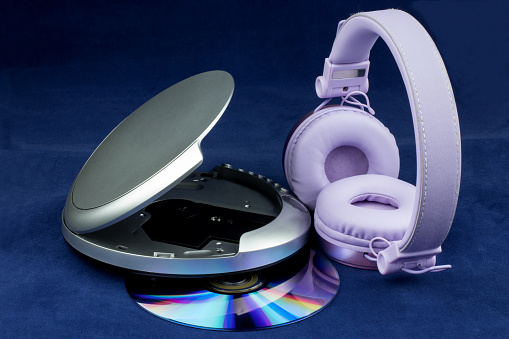 CD and CD player and headphones isolated on a blue background
