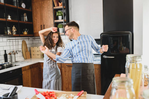 istock Young cheerful multi-ethnic couple preparing pasta together at their modern kitchen 1273914751