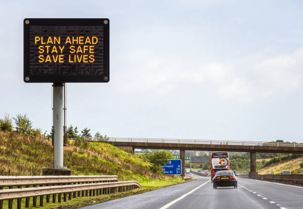 M80 Motorway, Scotland - Traffic passing a digital sign advising people to 'Plan Ahead, Stay Safe, Save Lives', part of public health measures to minimise the spread and impact of Covid-19.