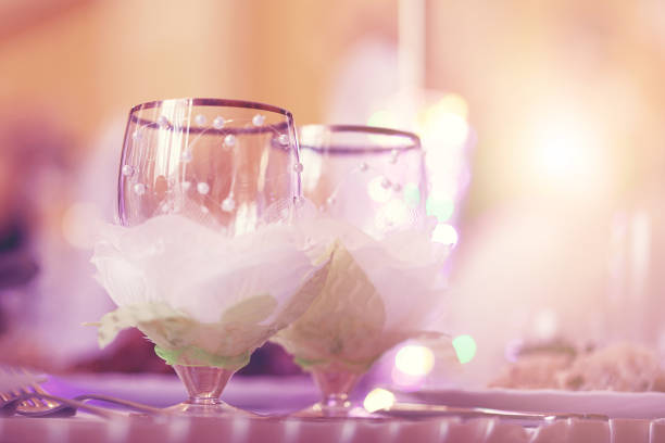 two empty wine glass staying on celebration table of restaurant gold wedding concept vintage toned