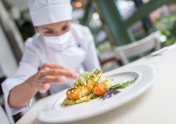 istock Chef wearing a facemask while decorating a plate at a restaurant during the pandemic 1273923081