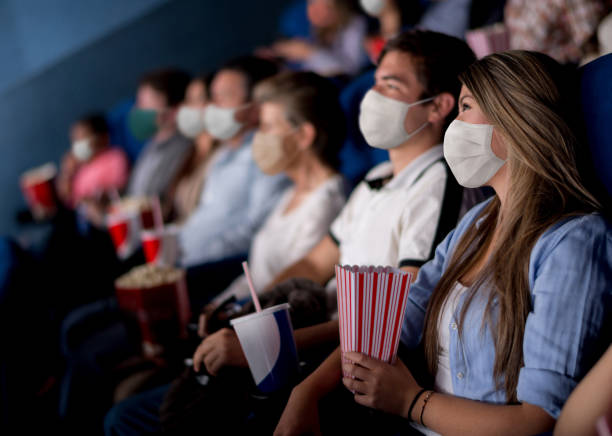 People at the cinema wearing facemasks while watching a movie