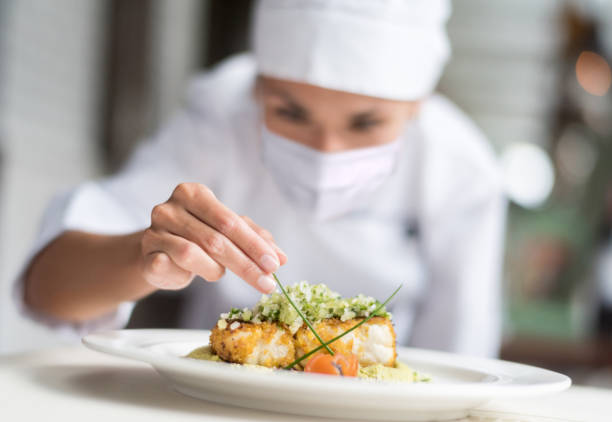 istock Chef decorating a plate at a restaurant while wearing a facemask during the pandemic 1273923093