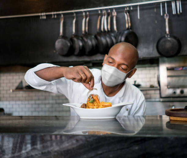 istock Chef decorating a plate at a restaurant while wearing a facemask during the pandemic 1273923119