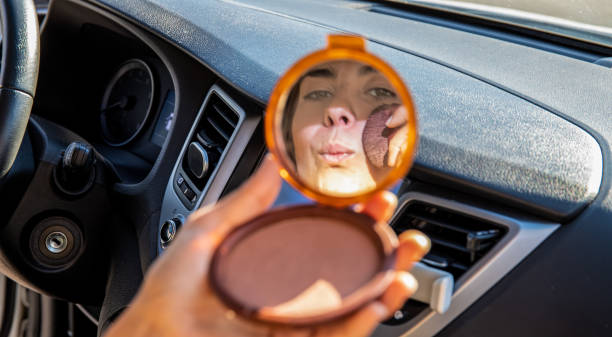 Crop woman applying makeup in car