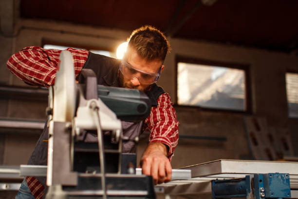 istock Young man work in home workshop garage with a grinder cuts metal bar 1273927626
