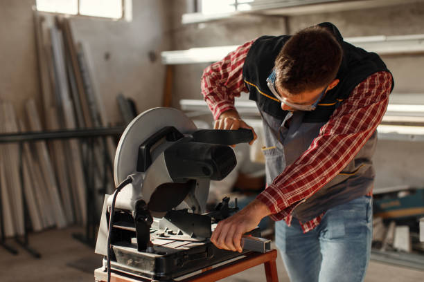 istock Young man work in home workshop garage with a grinder cuts metal bar 1273927662