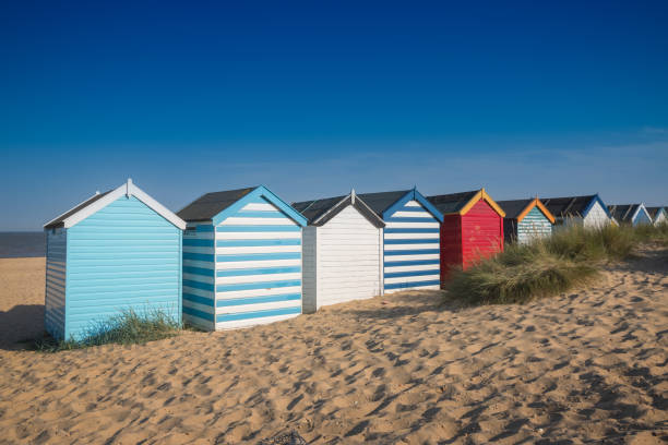 istock Colourful beach huts under a blue sky at Southwold beach in England 1273927940