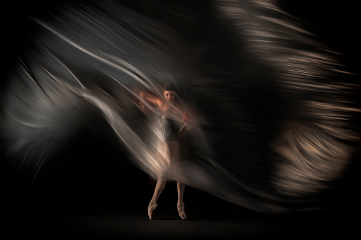 Ballerina is dancing behind thin nylon