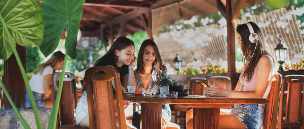 istock Beautiful young women enjoying in coffee shop while using a laptop 1273928032
