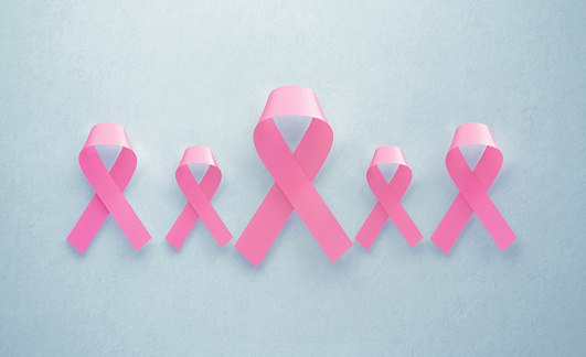 Pink breast cancer awareness ribbons on grey background. Horizontal composition with copy space. Breast cancer awareness concept.
