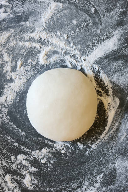 istock Dough ball on floured gray background. 1273934546