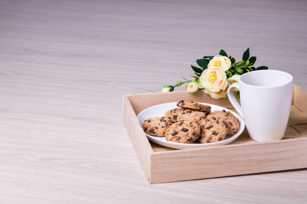 taca z ciasteczkami czekoladowymi, herbatą i kwiatami na drewnianym tle - chocolate chip cookie bakery chocolate homemade zdjęcia i obrazy z banku zdjęć