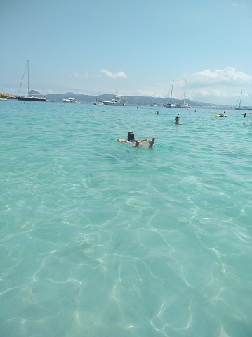 Image of a woman swimming in turquoise beach