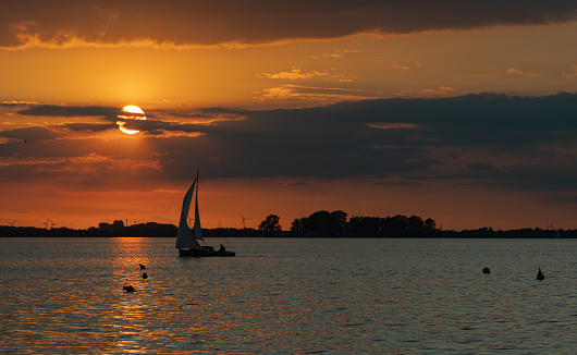 Lake with island and sailboat at sunset. Location: Lake Steinhuder Meer, Lower Saxonx, Germany