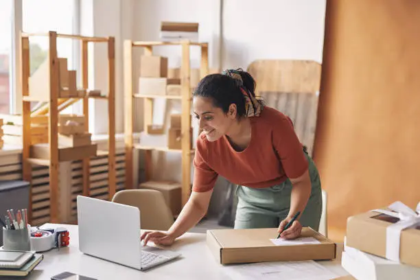 Photo of Woman completing orders by laptop