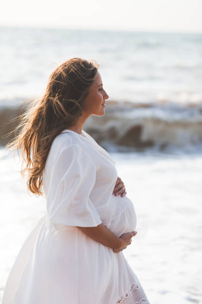 istock Pregnant woman at beach 1273940929