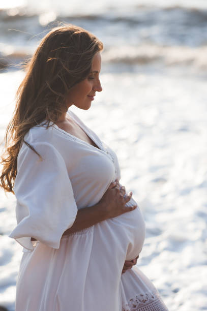 istock Pregnant woman at beach 1273940930