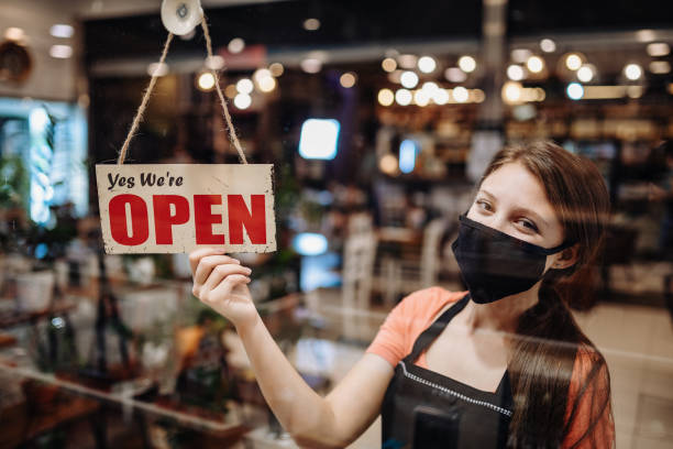 istock Waitress with face mask holding Open sign in cafe after coronavirus lockdown 1273942062