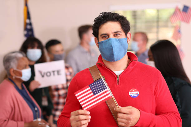 istock Latin descent man votes in USA election wearing mask. 1273942186