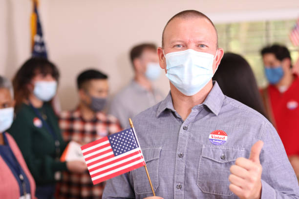 istock Man votes in USA election wearing mask. 1273942976