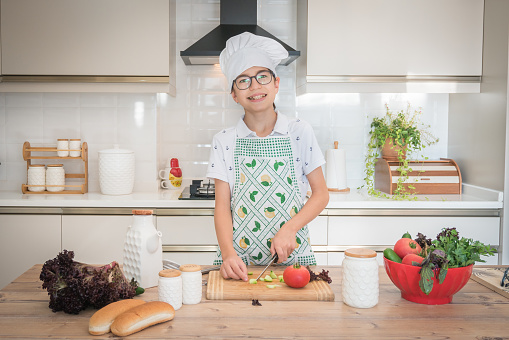 Happy boy making sandwiches in the kitchen