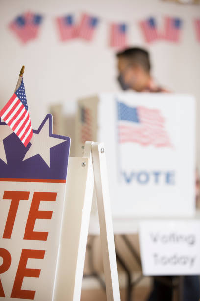 istock Vote Polling Place.  Everybody wears a protective face mask. 1273975448