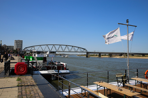 Nijmegen, Netherlands - September 18. 2020: View from river promenade over beyond container and cruise ship on river waal with snelbinder bridge background
