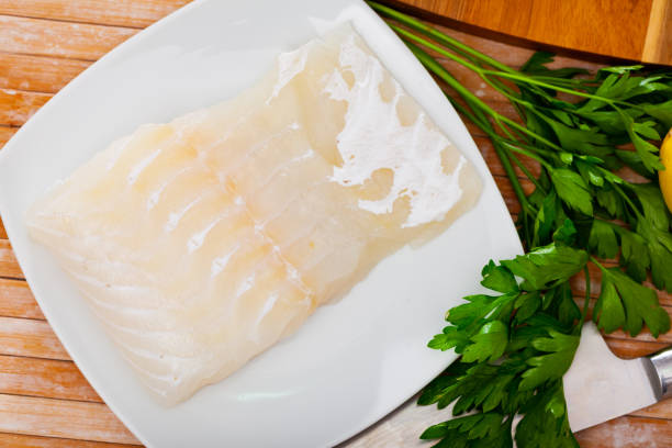 istock Raw fillet of pink cusk-eel with fresh greens 1274015571