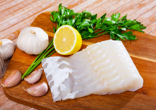 istock Uncooked rose eel fillet fish with parsley and garlic on table 1274015761