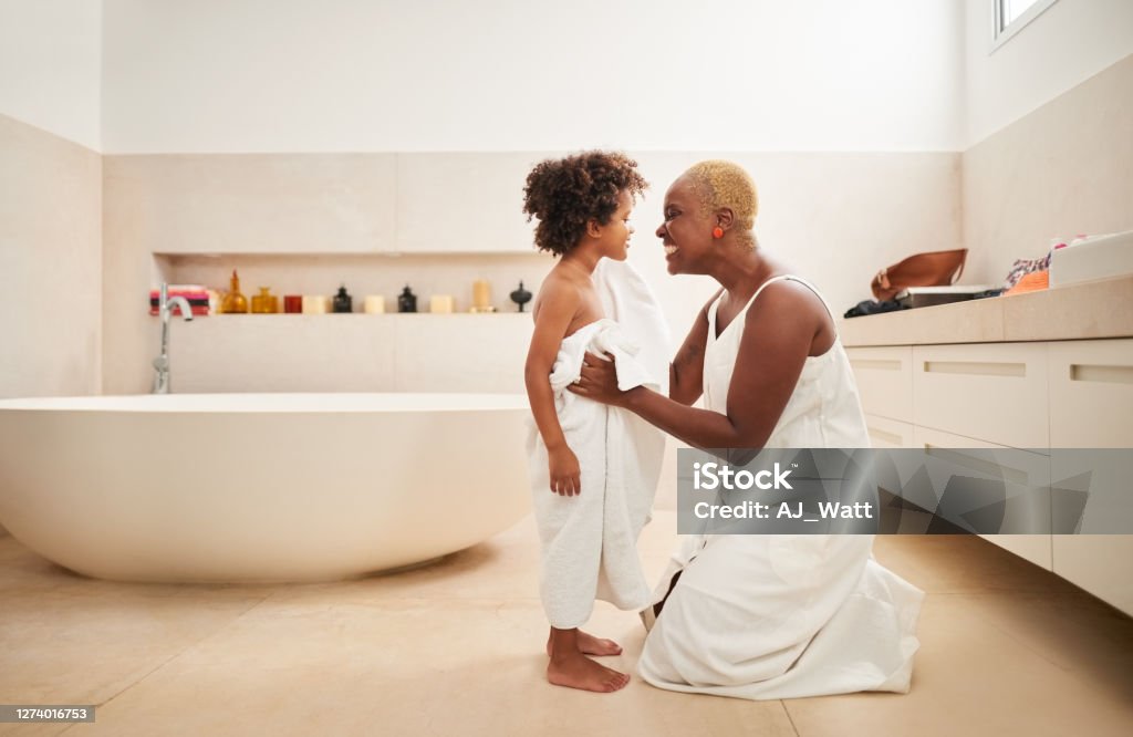 Drying off her son after bath Shot of a woman drying her son with towel his bath in bathroom Bathtub Stock Photo