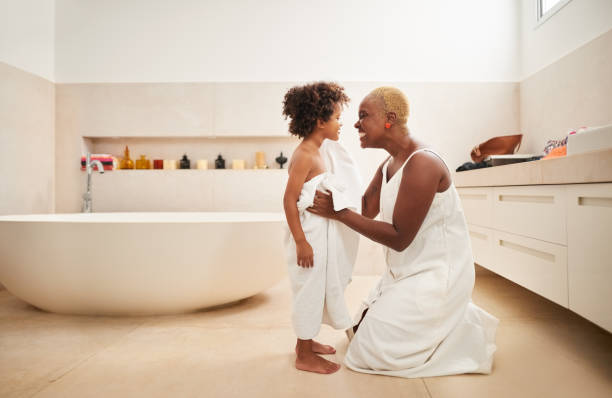 Drying off her son after bath Shot of a woman drying her son with towel his bath in bathroom drying photos stock pictures, royalty-free photos & images