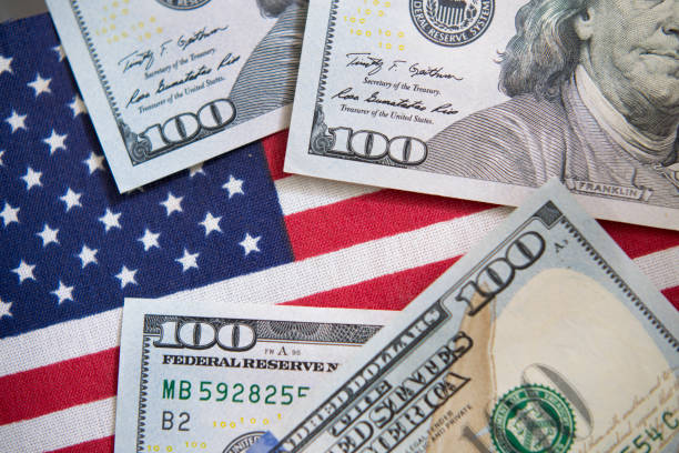 istock $100 dollar bills and American Flag. 1274024983