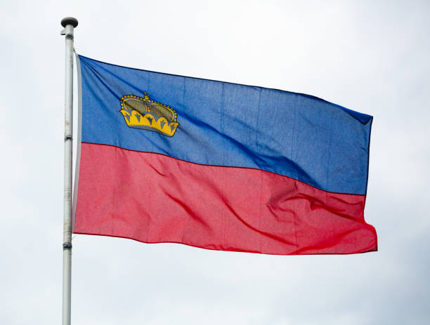 istock Flag of Liechtenstein waving on cloudy sky 1274027450