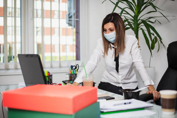 istock Businesswoman with her colleague disinfecting hands using alcohol 1274051472