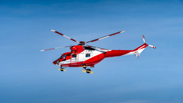istock Red and White mountain rescue helicopter on plain blue sky 1274055796