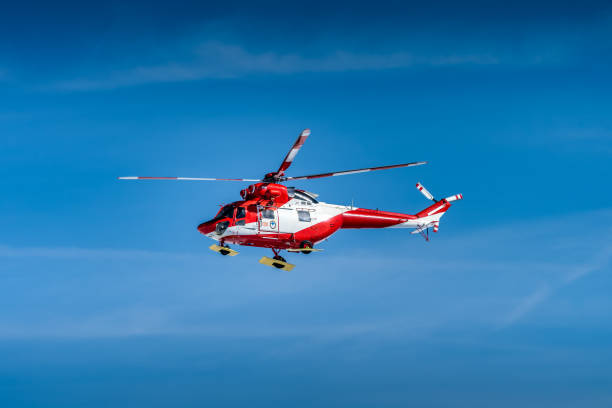 istock Red and White mountain rescue helicopter on plain blue sky 1274056641