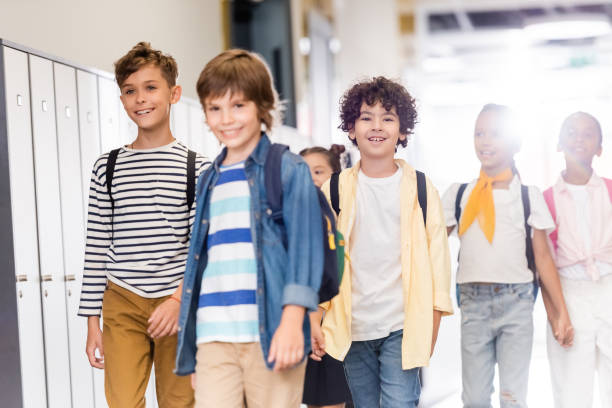 istock selective focus of multicultural classmates walking along corridor in school 1274064245