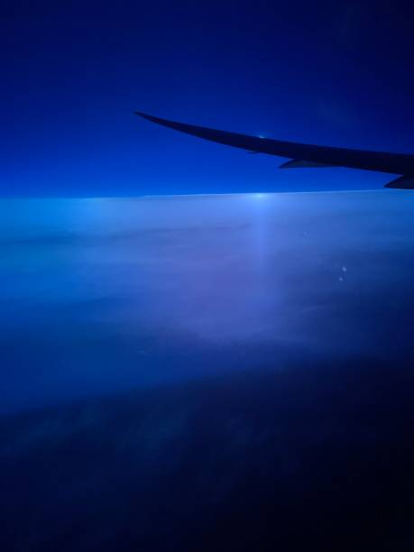 riflesso del sole sopra nuvole gonfie con cielo indizio - wing airplane window sunset foto e immagini stock
